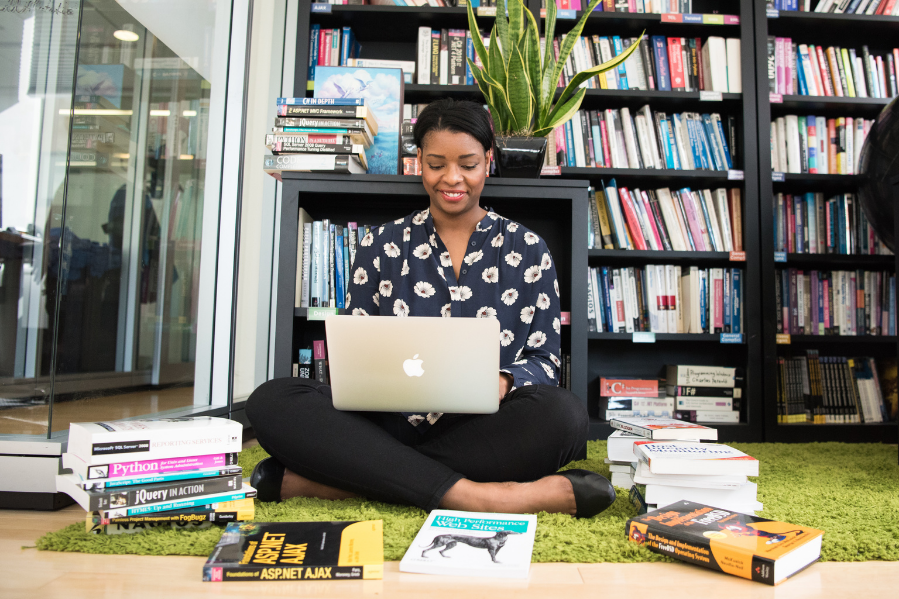 Woman at laptop with books